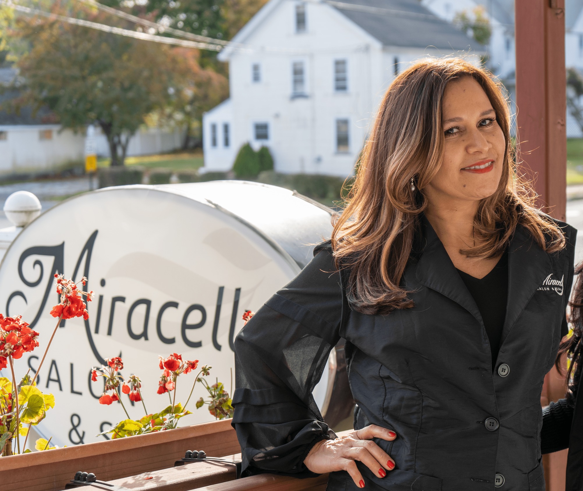 Miracelly Castro, owner of Miracelly Salon & Spa, beside the salon sign